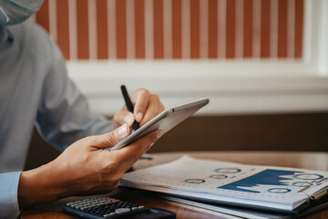 Fototapeta premium Business documents on office table with laptop and digital tablet and graph financial.