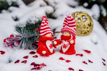 
Christmas toys stand on the branches of a snow-covered fir tree
