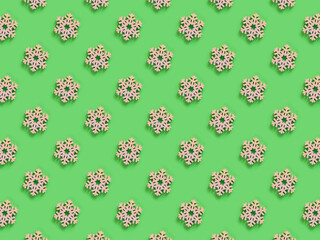 Beautiful pattern of the handmade wooden snowflake on the light green background. Christmas or New Year decoration.