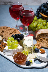 cheese plate, ciabatta, fresh grapes and red wine, vertical