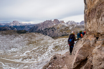 People climbing on a via ferrata route in the mountains. Adventure mountain activity. National Park Tre Cime di Lavaredo, Dolomiti Alps, South Tyrol, Italy