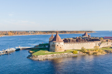 Fototapeta na wymiar Russia, Saint Petersburg, 09.10.2021. Oreshek Fortress is an ancient Russian fortress on Orekhov Island at the source of the Neva River at autumn. Petrokrepost Bay aerial view.