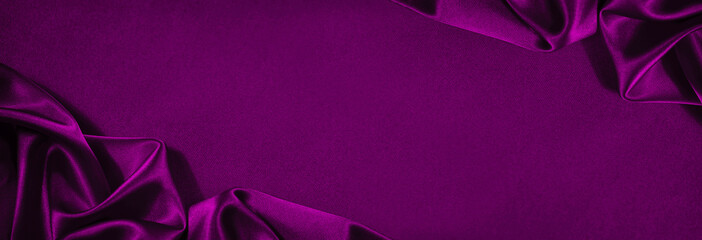 Purple silk satin. Soft wavy folds on shiny fabric. Luxury background with copy space for design....