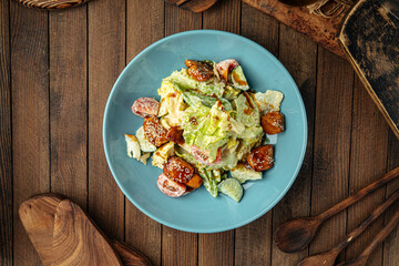 Portion of fresh mixed salad with fried chicken on wooden background