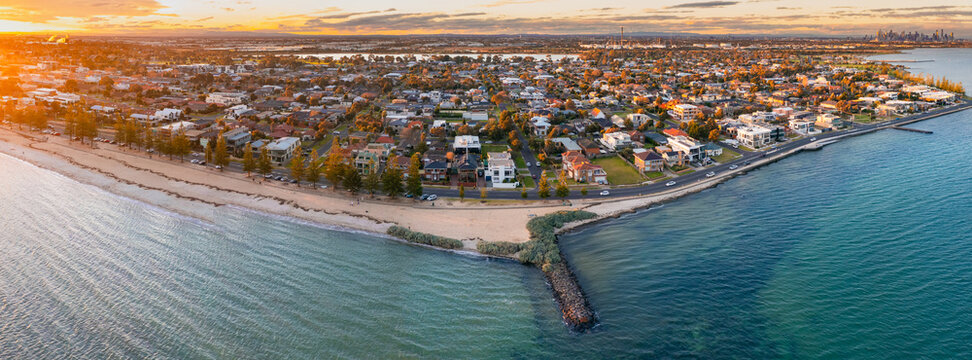 Panoramic aerial view of bay side suburb and beach at sunset