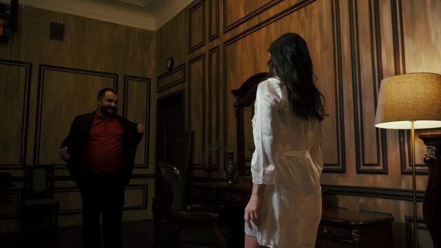 A man accosting a woman in a hotel room.
