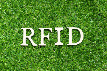 Alphabet letter in word RFID (Abbreviation of Radio-frequency identification) on green grass background