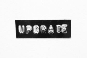 Black color banner that have embossed letter with word upgrade on white paper background