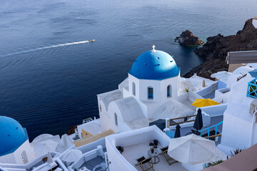 View from viewpoint of Oia village with blue domes of  greek orthodox Christian churches and traditional whitewashed greek architecture.  Santorini, Greece