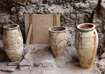  Recovered ancient pottery in prehistoric town of Akrotiri, excavation site of a Minoan Bronze Age settlement on the Greek island of Santorini - obrazy, fototapety, plakaty