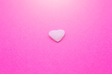 Fototapeta premium Pink heart on pink background. Saint Valentine's day concept. Love and romantic photo. Postcard for holiday. Beautiful warm wallpaper with love. Soft focus. Copy space.