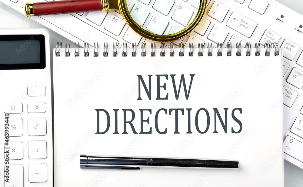 Poster new directions text on notepad with calculator and keyboard,business concept