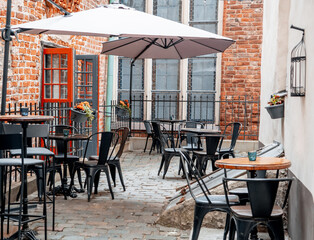 Summer cafe - tables, chairs and outdoor large sun umbrellas in the open air (1078)