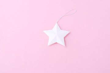 white paper star on soft pink background