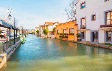 Red roof house surrounded by green trees and river - Scenic view on river Sorgue in colorful old town Lisle-sul-la-Sorgue - Provence, France