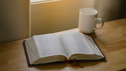 Fototapeta premium Open Bible and coffee in the morning on a wood table.