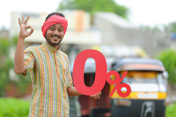 Indian auto driver showing zero percent board with his auto