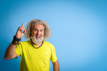 adult excited bearded hipster man in casual yellow shirt standing, holding index finger up with...