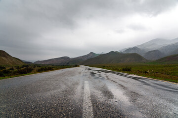 Wet asphalt road in mountainous area
