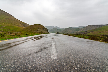 Wet asphalt road in mountainous area