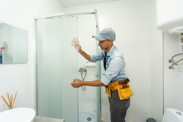 Plumber installing a shower cabin in bathroom