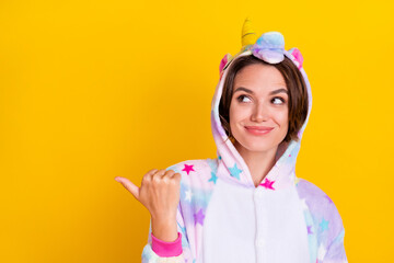 Photo of young happy woman smile enjoy look point finger empty space isolated on yellow color background