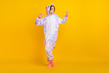 Fototapeta na wymiar Full length body size photo woman in unicorn costume dancing at party isolated vibrant yellow color background