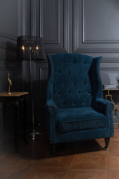 Classical library room with leather armchair, wooden table and bookcase.
