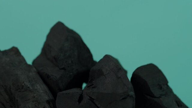 Wood charcoal. Black Charcoal on Blue green screen background. Used for cooking grill or industries. Natural wood charcoal. Black carbon reesidue produced by strongly heating wood. for grilled BBQ. 