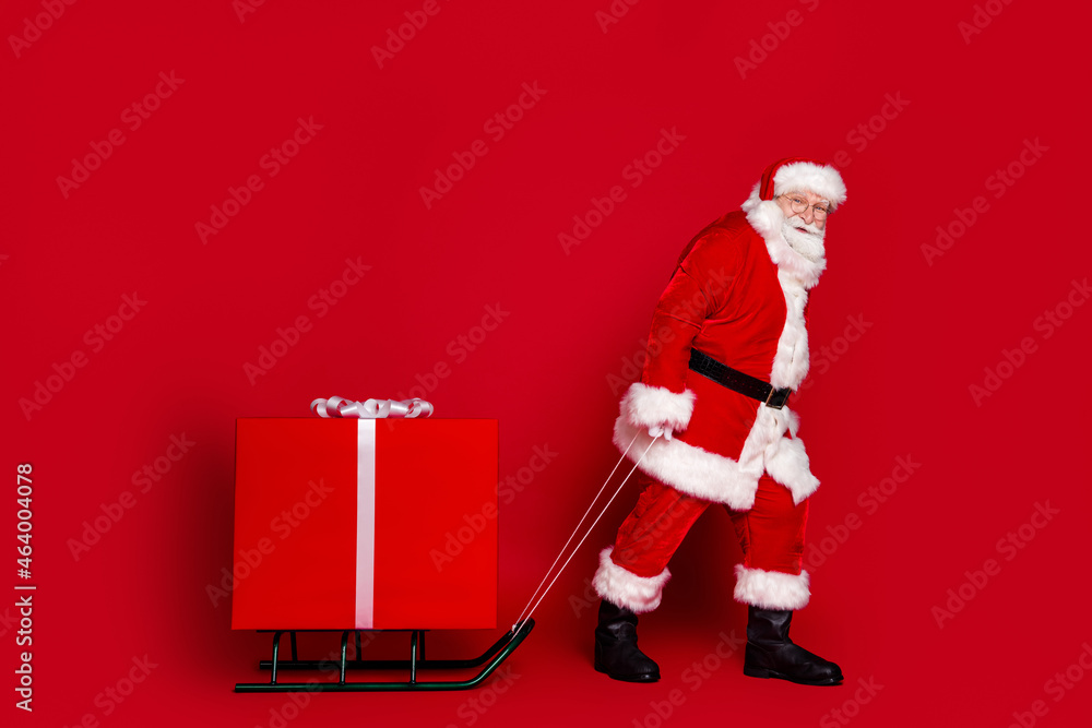 Wall mural photo of funky tired man pensioner dressed santa claus costume dragging big christmas gift smiling i