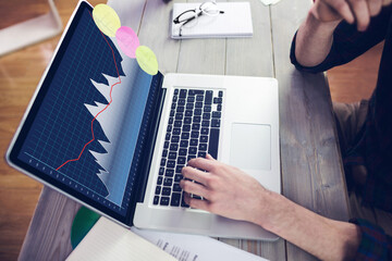 Hands of caucasian businessman sitting at desk, using laptop with statistical data on screen