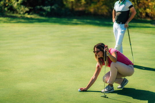 Young Couple Enjoying A Beautiful Autumn Day On The Golf Course