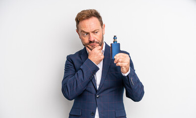 middle age handsome man thinking, feeling doubtful and confused smoking vaporizer concept
