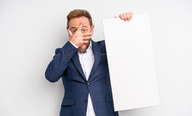 middle age handsome man looking shocked, scared or terrified, covering face with hand. copy space...