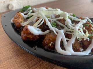 Veg Manchurian with gravy - Popular food of India made of cauliflower florets and other vegetable with myonese sauce over it. Selective focus.
