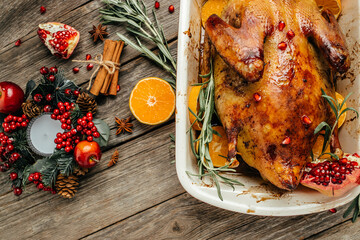 Roast Christmas duck with rosemary, thyme, berries and apples on rustic wooden table, banner, menu, recipe place for text, top view