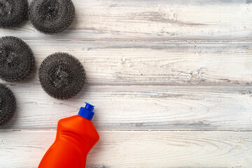 Home cleaning supplies on white wooden background, top view