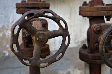 Stare zardzewiałe zawory przy zabytkowej wieży ciśnień. Old rusty valves at the historic water tower. - obrazy, fototapety, plakaty