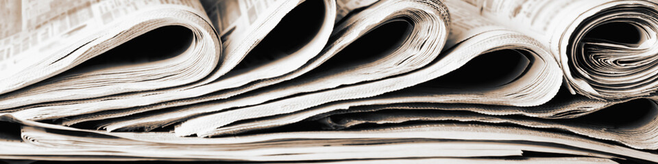 Panoramic image of old newspapers. Blur, selective focus. Media concept.
