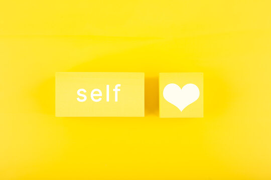 Self love minimal creative concept with yellow geometric figures with text on yellow background