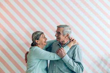 elderly couple in love hugs each other happy