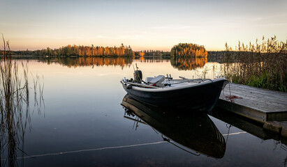 Fototapeta na wymiar Rowboat in beautiful evening lake scenery
