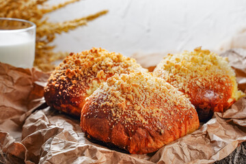 Good morning culinary food background. A glass of milk and fresh pastries on the table. Homemade buns sprinkled with cinnamon. Aromatic and mouth-watering breakfast