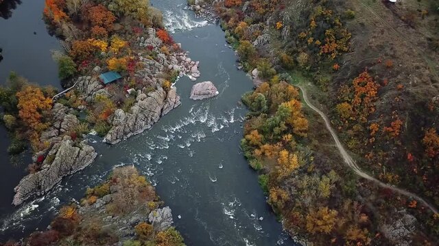 Aerial cinematic view of colorful autumn  trees and blue river. drone shot. 