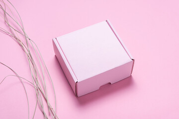 Pink cardboard box decorated with dried grass, mock up.