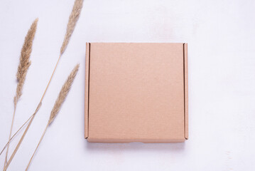 Brown cardboard box decorated with dried grass, mock up.