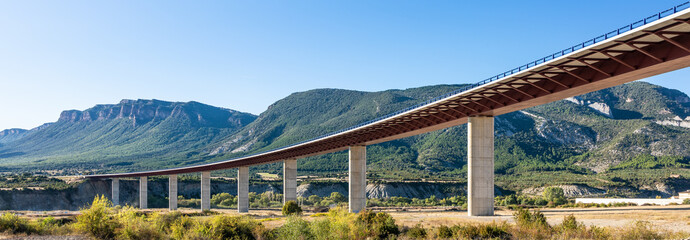 Modern bridge between mountains with bright day and clear skies