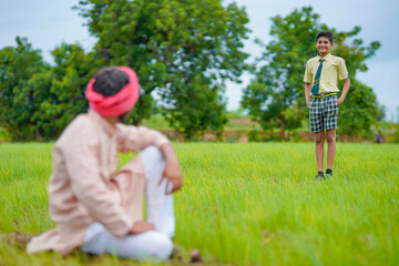 Indian farmer with his son at agriculture field.