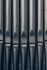 Traditional generic grey metal pipe organ pipes.