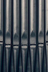 Traditional generic grey metal pipe organ pipes.